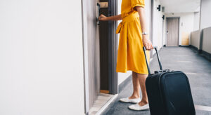 A woman with a suitcase entering a hotel room